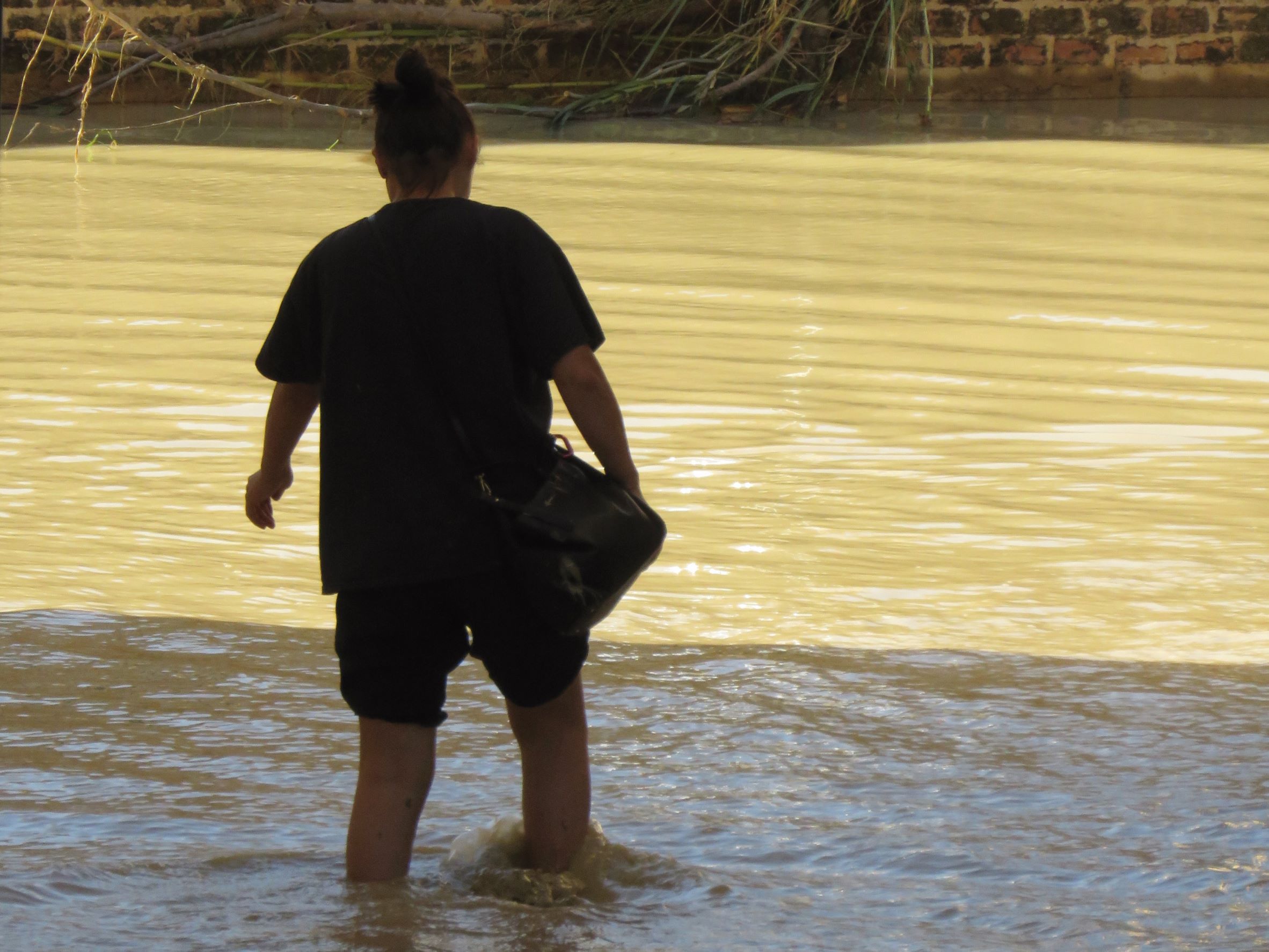 Una persona prova a camminare in mezzo ad acqua e fango durante l'alluvione che ha colpito Senigallia