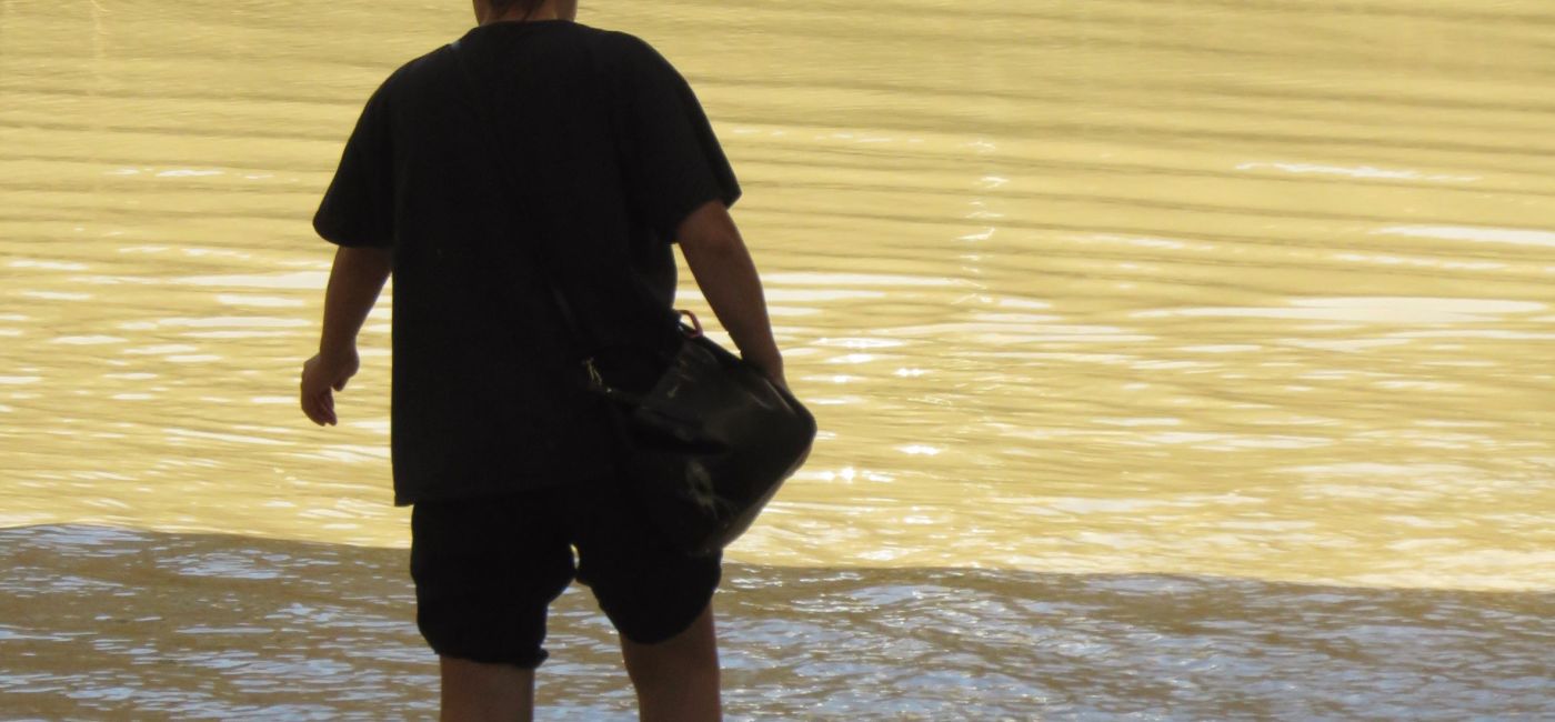 Una persona prova a camminare in mezzo ad acqua e fango durante l'alluvione che ha colpito Senigallia