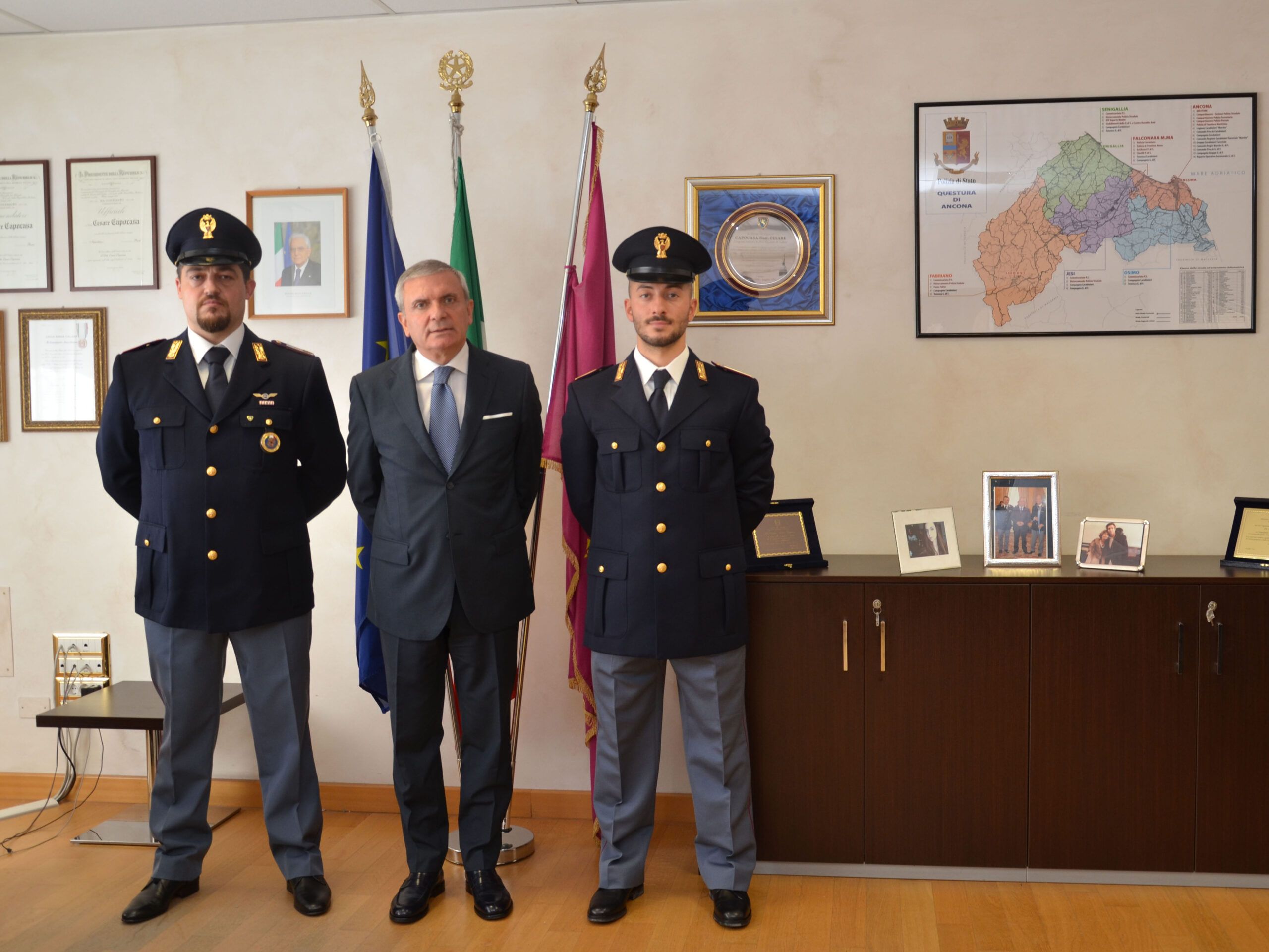 I poliziotti Daniele Romagnoli (a sinistra) e Mattia Marchetti (destra) al centro il questore di Ancona Cesare Capocasa